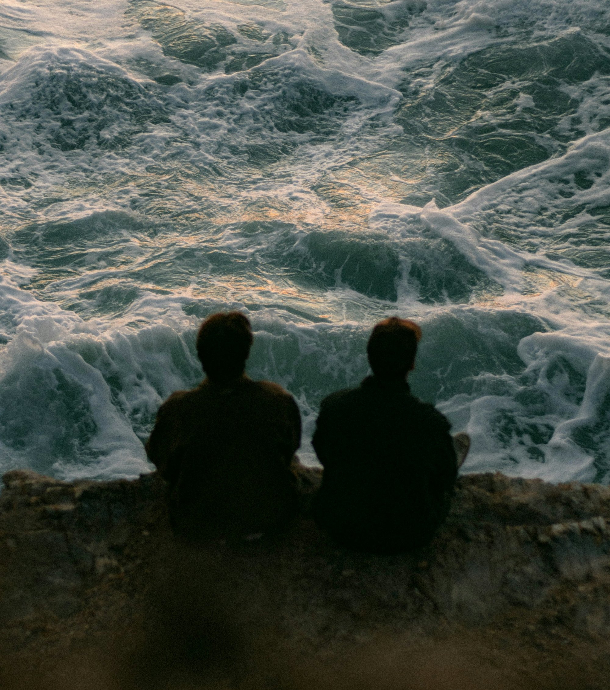 Two people walking side by side, seen from behind
