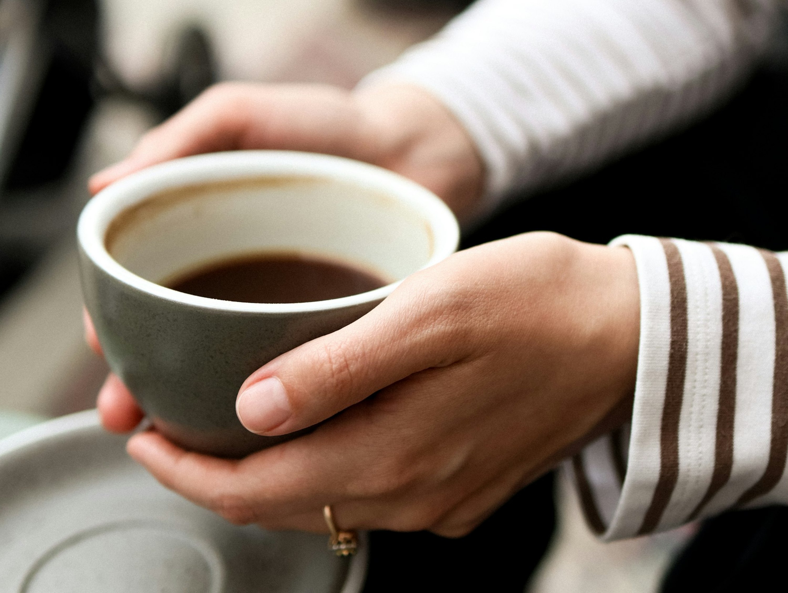 Hands resting around a warm mug